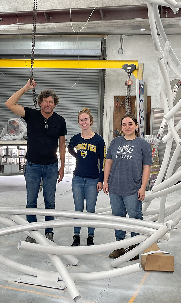 Torruella, Kelly and Sisson standing inside the sculpture.