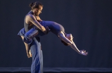 A pair of dancers, one of whom has their legs wrapped around the other's waist