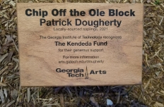 a wooden sign with explanatory text about the sculpture, Chip Off the Ole Block
