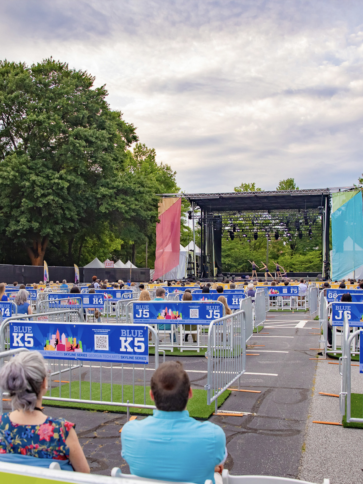 An outdoor stage is seen from the back audience
