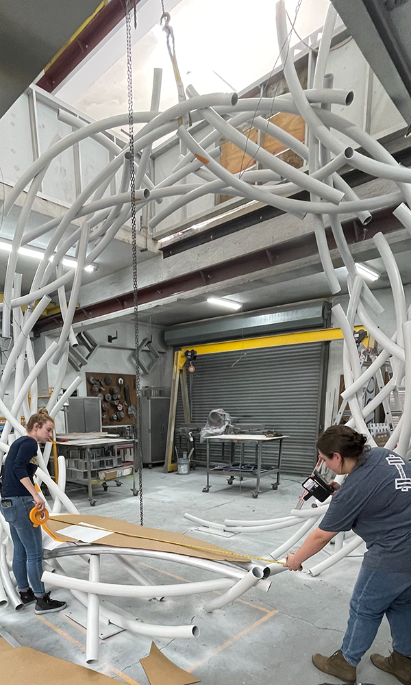 Elizabeth Kelly and Danielle Sisson taking measuring the bottom part of the sculpture.