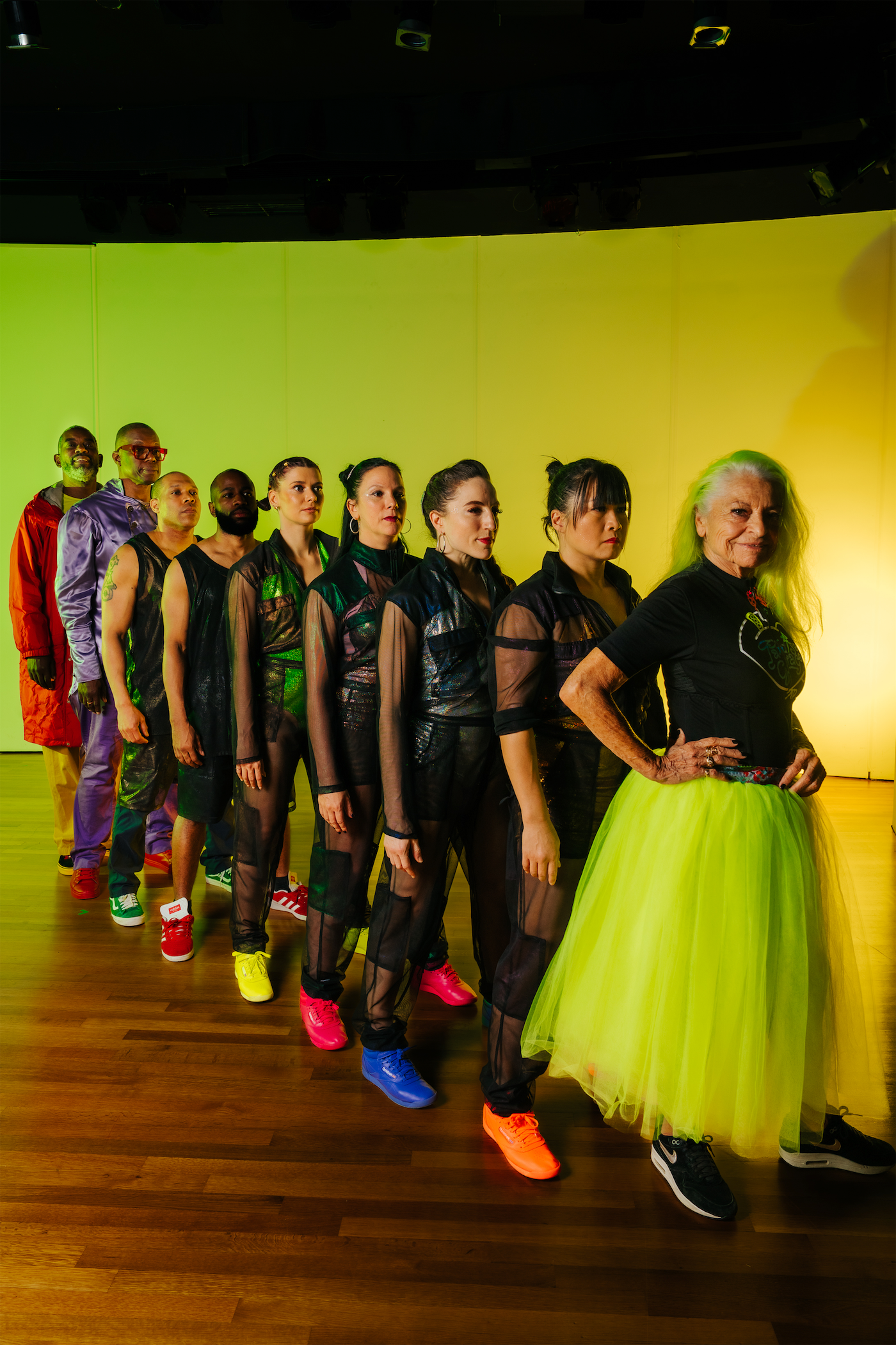 Dancers on stage with bright yellow and green background
