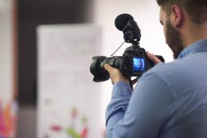 videographer-at-conference-seminar-taking-footage-and-recording-video-on-camera-SBI-322417620.jpg
