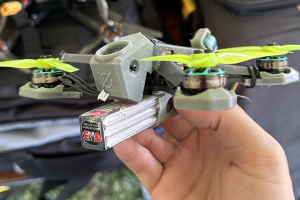 Multi-rotor drone racing device, held in hand by a pilot.