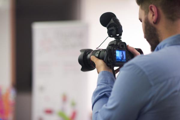 videographer-at-conference-seminar-taking-footage-and-recording-video-on-camera-SBI-322417620.jpg