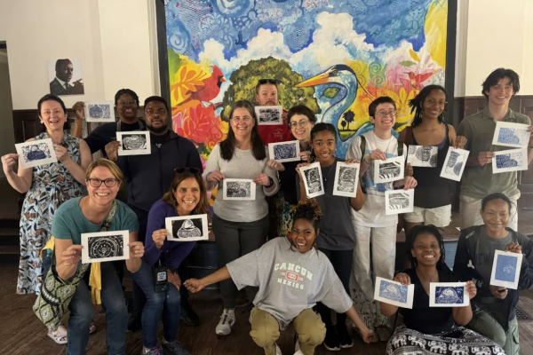 Group of people holding up art prints they made