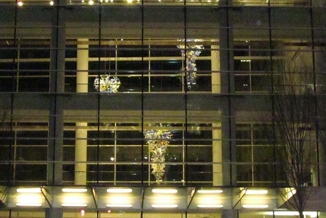 glass chandeliers seen through the three-story lobby glass windows of the Scheller College of Business