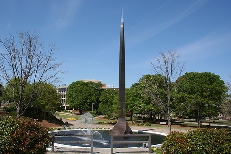 80 foot tall stainless steel spire based in a pool of water with fountains.
