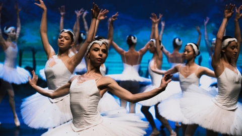 Ballet dancers wearing white with blue background 