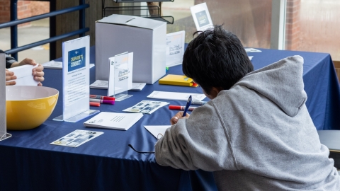 student writing note for campaign to connect