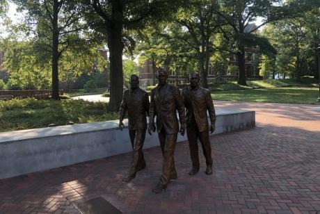 The figures of Ford Greene, Ralph Long Jr., and Lawrence Williams walking forward