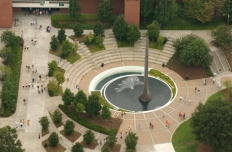 aerial view of the 80 foot tall stainless steel spire based in a pool of water with fountain spray