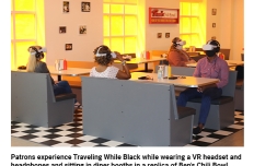 In a room with yellow tinted windows are sets of grey diner booths. people wearing virtual reality headsets are sitting at the booths.