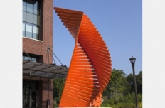 bright orange steel boards stacked in a twisted tower