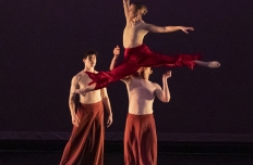 three dancers on stage with one lifted above another