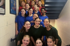 Group of dancers standing on staircase smiling at camera