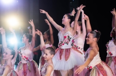 several ballet dancers with hands above head